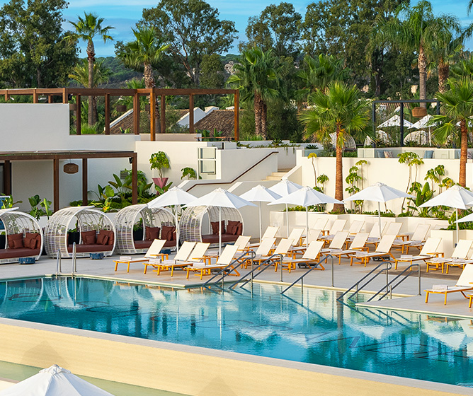 SO/ Sotogrande infinity pool with sun loungers and palm trees
